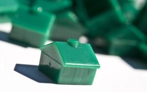 Green plastic houses arranged on a white surface.