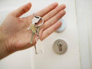 A person holding a key, symbolising access to a new home.