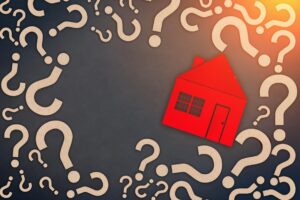Red house encircled by large, floating question marks.