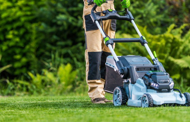 a man mowing a lawn with a lawn mower