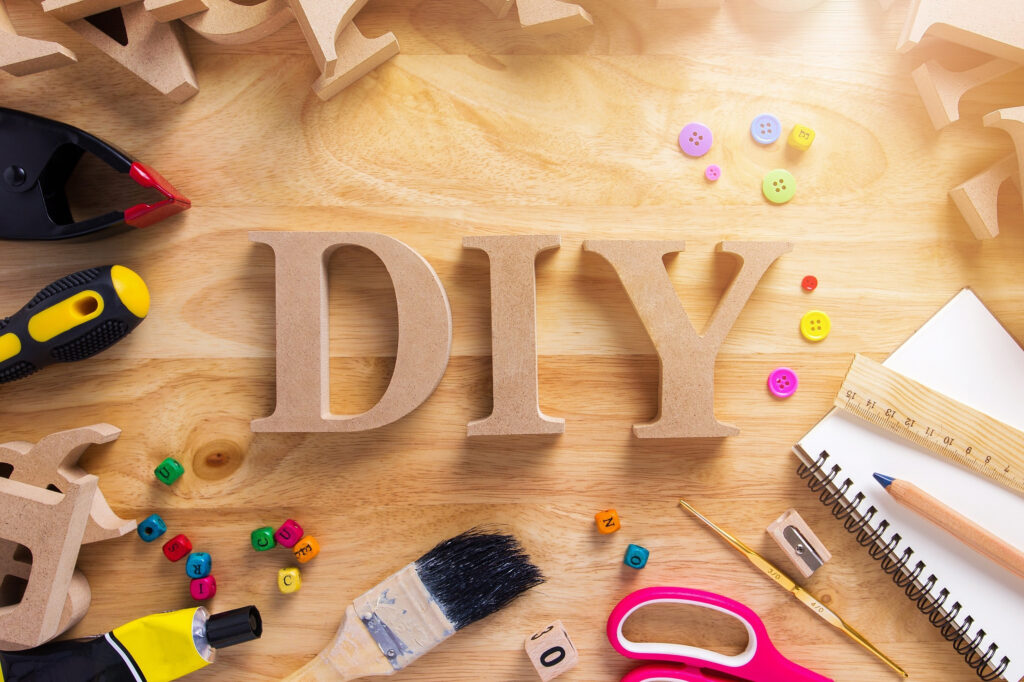 DIY wood crafts tools and supplies arranged on a wooden table.