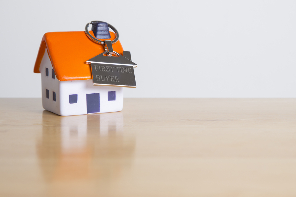 A house key resting on a wooden table.
