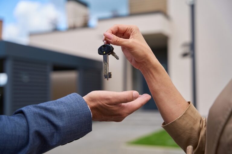 A person passing a key to another individual.