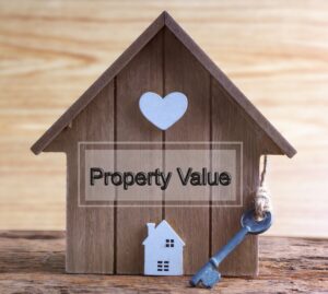 Wooden house model with a key, symbolising property investment.