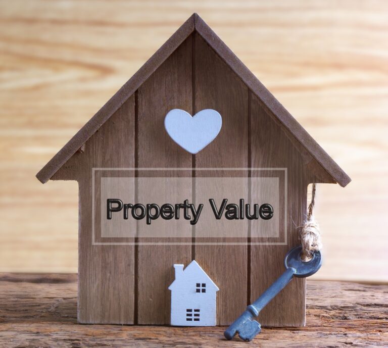 Wooden house model with a key, symbolising property investment.
