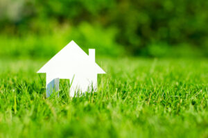 A small paper house nestled in lush green grass.