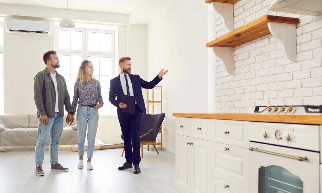 Estate agent presenting a modern home to a couple indoors, representing rising house prices and property demand in Brislington