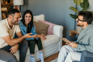 Letting agent discussing tenancy affordability with couple in living room