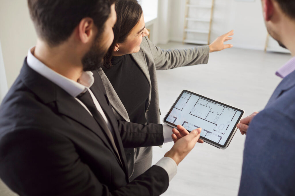 Estate agent presenting digital floor plan to home buyers during Southville property viewing