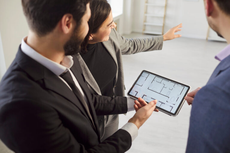 Estate agent presenting digital floor plan to home buyers during Southville property viewing