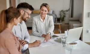 Letting agent discussing paperwork with a couple inside a home, representing Southville landlords planning stable family rental investments.