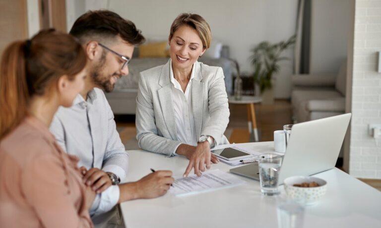 Letting agent discussing paperwork with a couple inside a home, representing Southville landlords planning stable family rental investments.