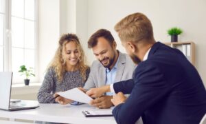 Estate agent discussing rental documents with clients, representing Long Ashton rental market advice, landlord yields and BS41 property management.