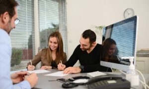 Landlords signing tenancy documents with a letting agent in Long Ashton while discussing the Renters' Rights Act and property compliance.