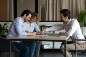 Couple signing property documents with an estate agent, representing homeowners getting a property valuation in Brislington.