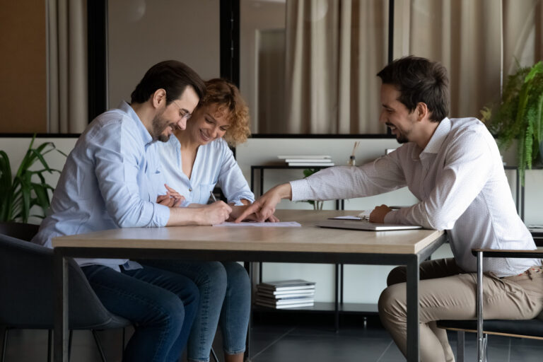 Couple signing property documents with an estate agent, representing homeowners getting a property valuation in Brislington.