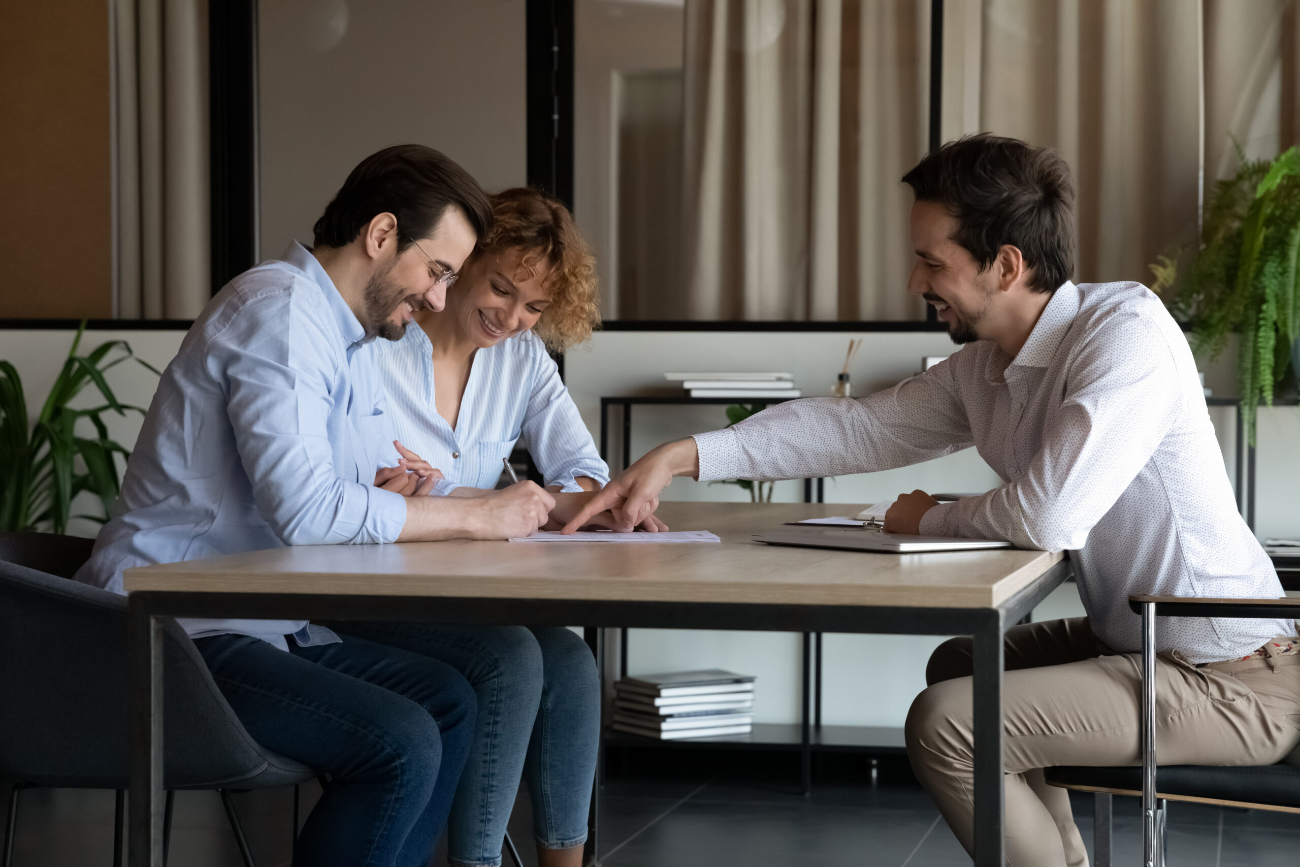 Couple signing property documents with an estate agent, representing homeowners getting a property valuation in Brislington.