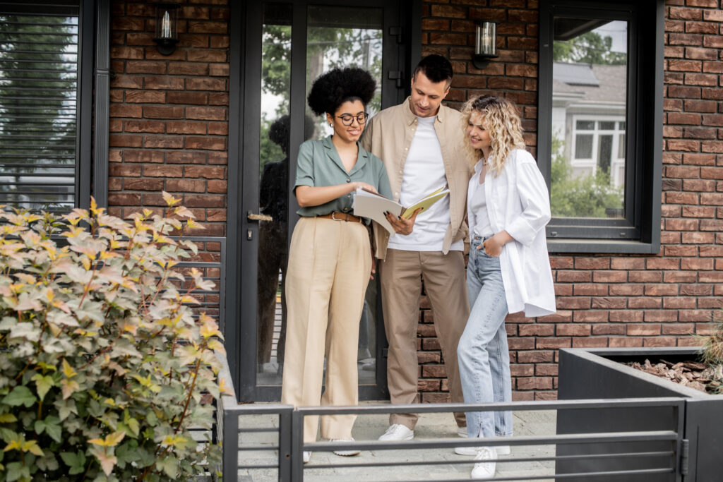 Estate agent discussing property details with a couple outside a modern home in Bishopsworth, reflecting the local property market and home-selling process.
